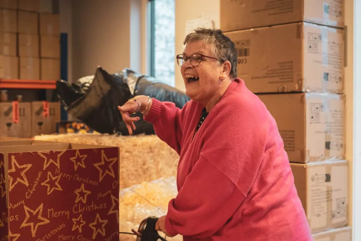 Medewerker pakt kerstpakketten in op een sociale ontwikkelplek