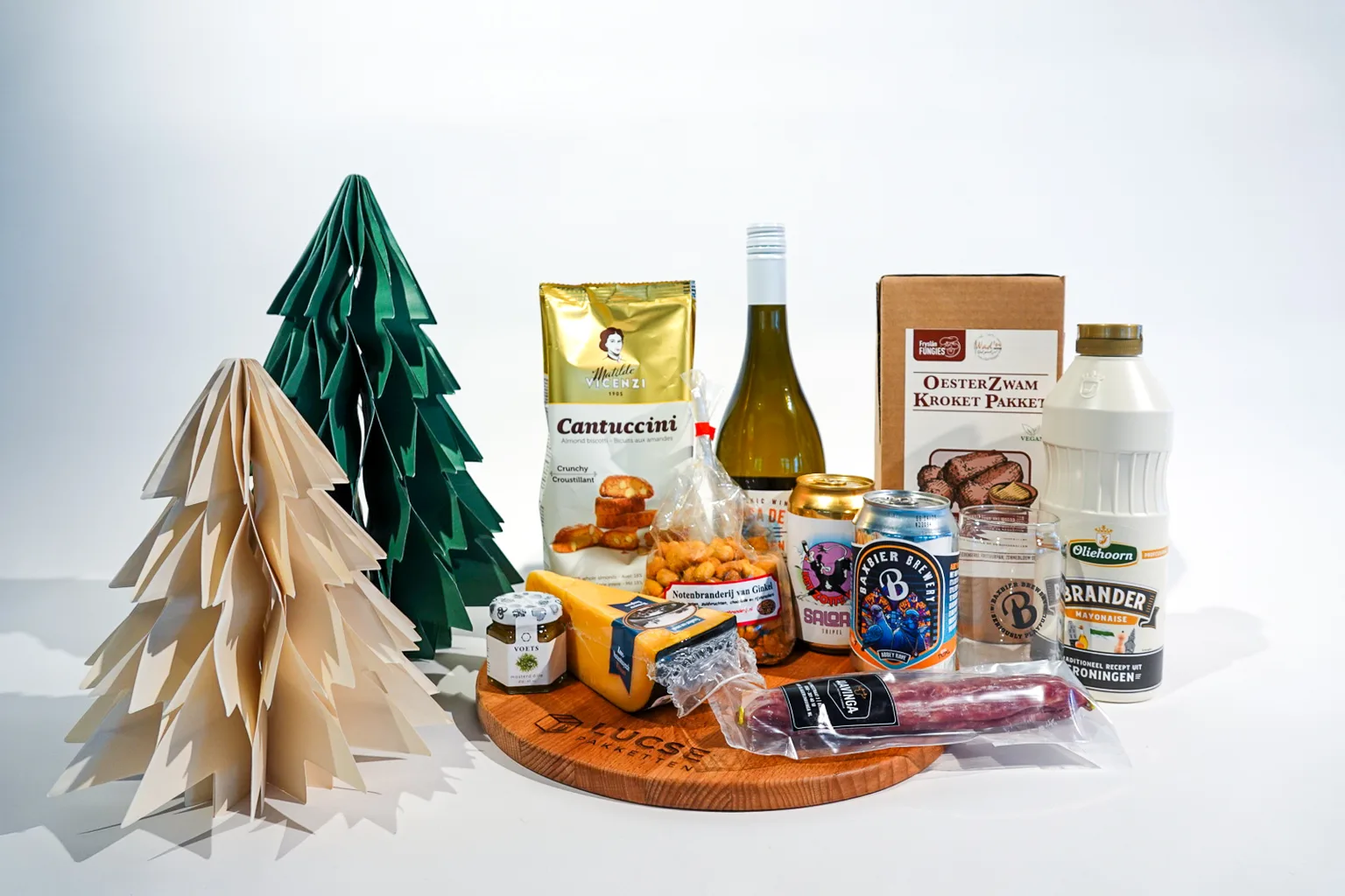 Kerstpakket op een houten serveerplank met logo, met kaas, droge worst, bier, wijn en een vegan kroketpakket