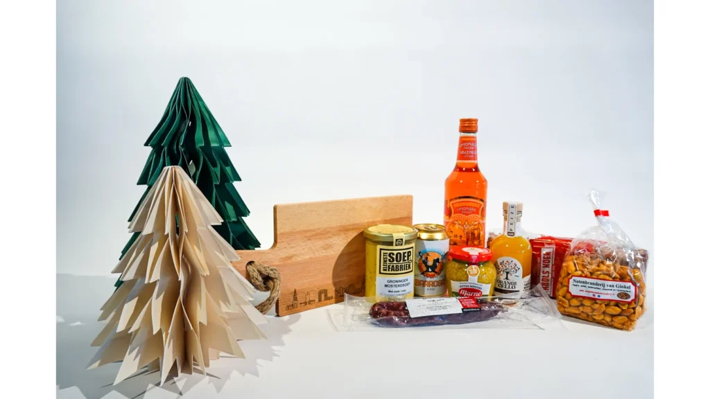 Kerstpakket met Groningse mosterdsoep, mosterd, droge worst, likeur en noten op een houten plank
