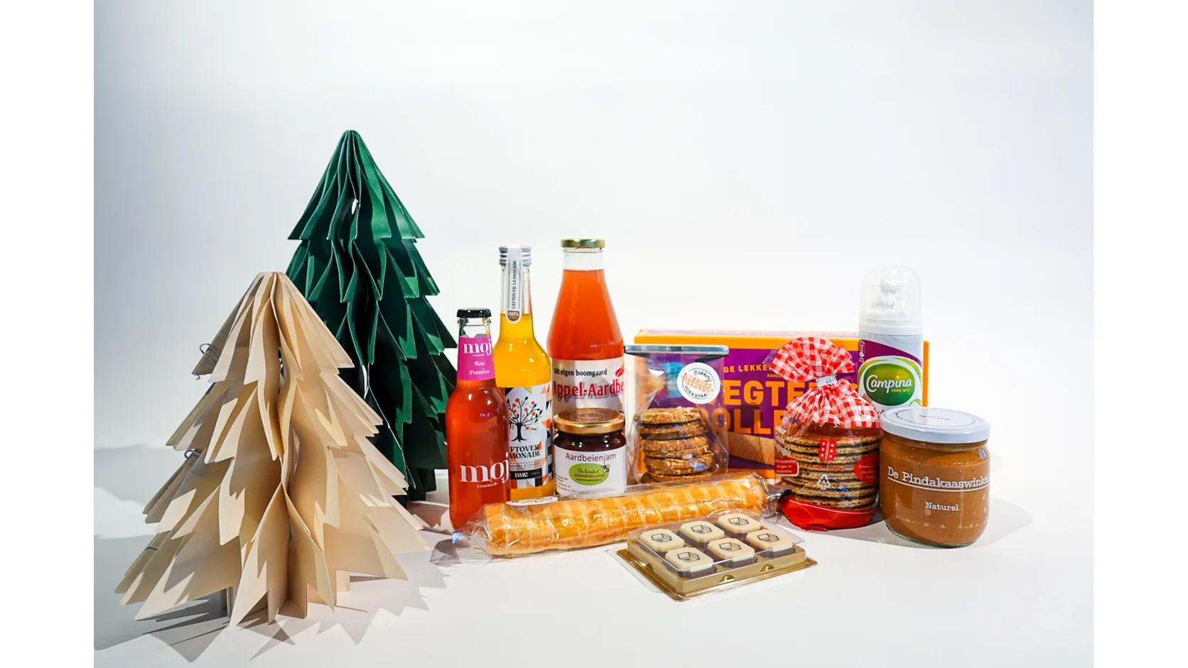 Kerstpakket met drankjes, koek, jam en papieren kerstbomen