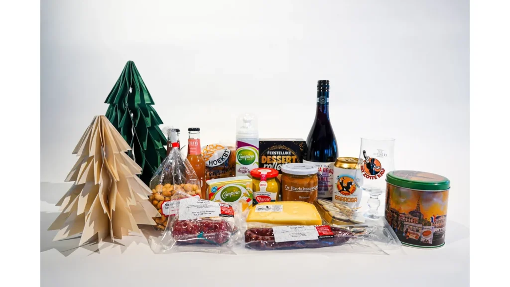 Kerstpakket met wijn, bier met bierglas, kaas, droge worst, mosterd, noten en een bewaarblik met Gronings stadsgezicht